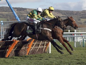 Race winner Buveur D'Air ridden by Barry Geraghty, foreground, clears the last hurdle alongside Melon, ridden by Paul  Townend,  as they race  to finish-line in the Champion Hurdle at Cheltenham Racecourse, Cheltenham England Tuesday March 13, 2018.