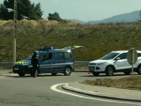 In this image taken from BFM TV shows a police vehicle parked on a crossroad in Trebes, southern France, near the scene of an incident, Friday March 23, 2018. French counterterrorism prosecutors are taking charge of the investigation into the shooting of a police officer in southern France that has led to an apparent hostage-taking at a supermarket. (BFM TV via AP)
