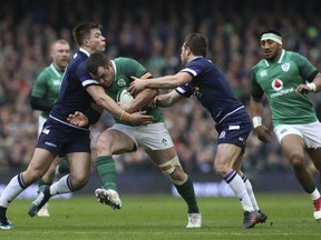 Scotland's Huw Jones, left, and Greig Laidlaw, right, tackle Ireland's Cian Healy during the Six Nations rugby match at the Aviva Stadium in Dublin, Ireland, Saturday March 10, 2018.