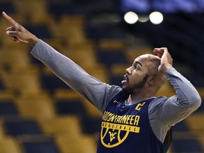 West Virginia's Jevon Carter points towards the scoreboard prior to a practice at the NCAA men's college basketball tournament in Boston, Thursday, March 22, 2018. West Virginia faces Villanova in a regional semifinal on Friday night.