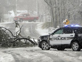 Sandwich Police block Route 6A at the Quaker Meetinghouse intersection where a tree downed live wires during a snowstorm, Tuesday, March 13, 2018 in Sandwich, Mass.