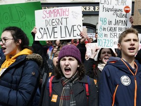 Boston area students chant on the Statehouse steps during a rally in Boston, Wednesday, March 14, 2018. As part of a nationwide school walkout, students from several Boston area schools, closed after Tuesday's snowstorm, marched from a downtown church to the Statehouse to urge lawmakers to pass legislation aimed at stemming gun violence.