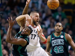 Boston Celtics' Kadeem Allen, left, and Toronto Raptors' Jonas Valanciunas (17) battle for a rebound during the second quarter of an NBA basketball game in Boston, Saturday, March 31, 2018.