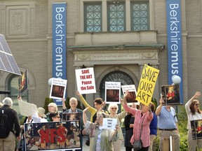 In a Saturday, Aug. 12, 2017 file photo, people opposed to the selling of The Berkshire Museum's art to fund an expansion and endowment, protest in front of museum in Pittsfield, Mass. A judge on Massachusetts' highest court is stepping into a fight over the proposed sale of works of art by the cash-strapped museum. A hearing before a single justice of the Supreme Judicial Court is set for Tuesday, March 20, 2018 in Boston.