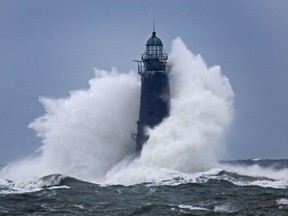Waves crash against Minot Light off the Scituate coast off Massachusetts, Sunday, March 4, 2018 as a large nor'easter that hit over the weekend continues to batter the coast. The 89-foot-tall lighthouse was built in 1855.