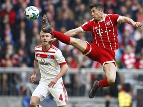 Bayern's Robert Lewandowski jumps for the ball besides Hamburg's Rick van Drongelen during the German Soccer Bundesliga match between FC Bayern Munich and Hamburger SV in Munich, Germany, Saturday, March 10, 2018.