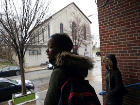 In this March 20, 2018 photo, student Imani Holt waits for a bus after school at Excel Academy in Baltimore. Students at Excel agree that their high school provides a sense of security. But the toll of gun violence on their bodies and minds is significant. Nerves are on edge. It can be hard to concentrate.