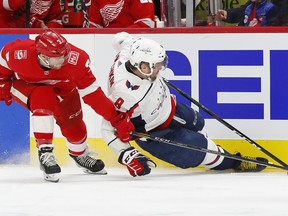 Washington Capitals' Alex Ovechkin (8) tries to control the puck as he hits the ice, while Detroit Red Wings defenseman Nick Jensen defends during the first period of an NHL hockey game Thursday, March 22, 2018, in Detroit.