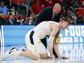 Purdue center Isaac Haas reacts to landing on the floor as a trainer attends to him against Cal State Fullerton during the second half of an NCAA men's college basketball tournament first-round game in Detroit, Friday, March 16, 2018.