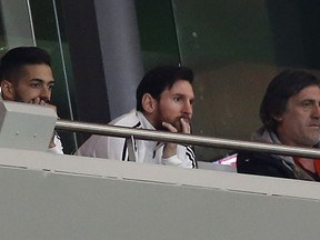 Argentina's Lionel Messi, center, watches from the tribune during the international friendly soccer match between Spain and Argentina at the Wanda Metropolitano stadium in Madrid, Spain, Tuesday March 27, 2018.