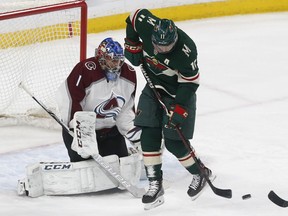 Minnesota Wild's Zach Parise, right, waits for the pass as Colorado Avalanche goalie Semyon Varlamov, of Russia, defends in the first period of an NHL hockey game, Tuesday, March 13, 2018, in St. Paul, Minn.