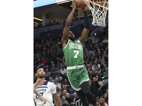 Boston Celtics's Jaylen Brown lays up as Minnesota Timberwolves' Taj Gibson, left, looks on in the first half of an NBA basketball game Thursday, March 8, 2018, in St. Paul, Minn.