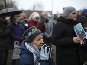In this Tuesday, March 20, 2018, photo, a crowd listens as Katherine Hamberg speaks at the rally in Minneapolis, near where Justine Damond was shot last July. A Minneapolis police officer was charged Tuesday with murder and manslaughter in the fatal shooting of Damond, an unarmed Australian woman, minutes after she called 911 to report a possible sexual assault behind her home.