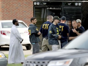 FILE - In this Aug. 15, 2017 file photo, Law enforcement officials investigate an explosion at the Dar Al-Farooq Islamic Center in Bloomington, Minn. Federal authorities said Tuesday, March 13, 2018, they have charged three men from rural central Illinois with the bombing of a Minnesota mosque last year and one of the men told an investigator the goal of the attack was to "scare" Muslims out of the United States. A statement from the U.S. attorney's office in Springfield, Illinois, says the men also are suspected in the attempted bombing of an abortion clinic in November.