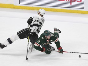 Minnesota Wild's Zach Parise (11) and Los Angeles Kings Derek Forbort (24) fall while going after the puck in the first period of an NHL hockey game Monday, March 19, 2018, in St. Paul, Minn.