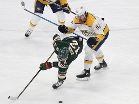 Minnesota Wild's Eric Staal (12) tries to control the puck against Nashville Predators' Ryan Johansen (92) in the first period of an NHL hockey game Saturday, March 24, 2018, in St. Paul, Minn.