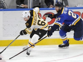 St. Louis Blues' Alex Pietrangelo (27) and Boston Bruins' Brad Marchand (63) reach for the puck during the first period of an NHL hockey game Wednesday, March 21, 2018, in St. Louis.