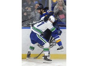 Vancouver Canucks' Nikolay Goldobin (77), of Russia, checks St. Louis Blues' Robert Bortuzzo (41) during the first period of an NHL hockey game, Friday, March 23, 2018, in St. Louis.