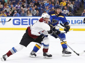 Colorado Avalanche's Sven Andrighetto, left, of Switzerland, and St. Louis Blues' Carl Gunnarsson, of Sweden, race for a loose puck during the first period of an NHL hockey game Thursday, March 15, 2018, in St. Louis.