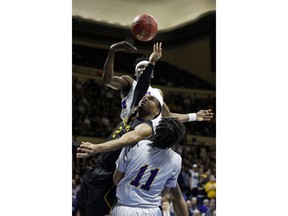 Graceland guard LT Davis, middle, has the ball knocked away by LSU Alexandria forward Brandon Moss, top, as Chris Vickers, bottom, also defends during the first half of the NAIA men's championship college basketball game Tuesday, March 20, 2018, in Kansas City, Mo.