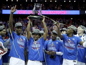 Kansas players celebrate after winning the NCAA college basketball championship game against West Virginia in the Big 12 men's tournament Saturday, March 10, 2018, in Kansas City, Mo. Kansas won 81-70.