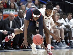Mississippi 's Terence Davis, left, and South Carolina's Evan Hinson collide as they chase a loose ball during the first half in an NCAA college basketball game at the Southeastern Conference tournament Wednesday, March 7, 2018, in St. Louis.