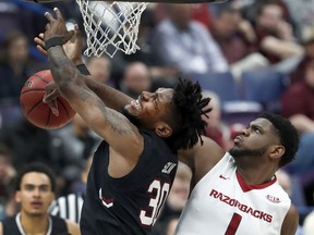 South Carolina's Chris Silva (30) has the ball knocked away by Arkansas' Trey Thompson (1) during the first half in an NCAA college basketball game at the Southeastern Conference tournament Thursday, March 8, 2018, in St. Louis.
