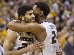 Missouri's Kevin Puryear, right, hugs teammate Jordan Barnett, left, after they defeated Arkansas in an NCAA college basketball game Saturday, March 3, 2018, in Columbia, Mo.