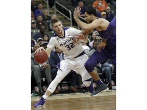 Kansas State forward Dean Wade (32) looks for room around TCU forward Ahmed Hamdy-Mohamed (23) during the first half of an NCAA college basketball game in quarterfinals of the Big 12 men's tournament in Kansas City, Mo., Thursday, March 8, 2018.