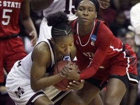Mississippi State guard Roshunda Johnson, left, is tied up by North Carolina State guard Kaila Ealey, right, during the first half of a women's NCAA college basketball tournament regional semifinal game, Friday, March 23, 2018, in Kansas City, Mo.