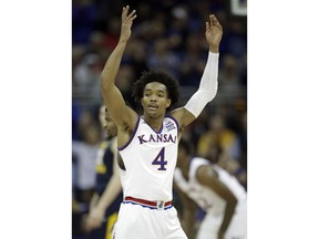 Kansas guard Devonte' Graham (4) encourages fans during the first half of an NCAA college basketball game against West Virginia in the finals of the Big 12 men's tournament in Kansas City, Mo., Saturday, March 10, 2018.