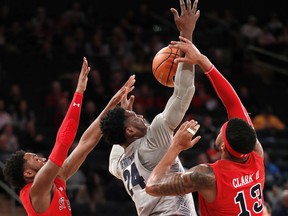 St. John's guard Shamorie Ponds (2) defends as teammate Marvin Clark II (13) strips the ball from Georgetown forward Marcus Derrickson (24) during the first half of an NCAA college basketball game in the first round of the Big East conference tournament, Wednesday, March 7, 2018, in New York.