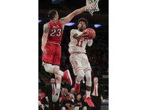 Utah forward Chris Seeley (11) shoots against Western Kentucky forward Justin Johnson (23) during the first half of an NCAA college basketball game during the semifinals of the NIT Tuesday, March 27, 2018, in New York.