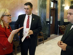 FILE - In a Friday, Feb. 2, 2018 file photo, Terri Herring, left, a long time Mississippi abortion foe, speaks with House Judiciary B Committee chairman Andy Gipson, R-Braxton, center, and Rep. Chris Brown, R-Nettleton, outside chambers at the Capitol in Jackson, Miss., following the passage of House Bill 1510, which makes the state the first to ban most abortions after 15 weeks of pregnancy. Mississippi's governor signed the nation's most restrictive abortion law Monday, March 19, 2018, and was slapped with a lawsuit less than an hour later.