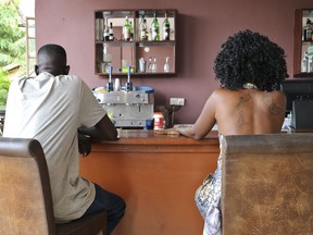 In this photo taken Friday, March 2, 2018, sex worker Nancy sits at a local bar where she sometimes picks up clients, in Juba, South Sudan. As World Women's Day is to be marked across the globe and women across much of the Western world have galvanized around the #MeToo movement, South Sudan remains a place where women face grinding difficulties and rights experts say most women remain voiceless. (AP Photo)