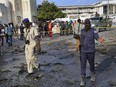 Security forces attend the scene after a car bomb explosion near the parliament building in the capital Mogadishu, Somalia Sunday, March 25, 2018.