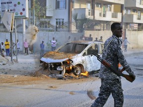 A Somali soldier attends the scene after a bomb attack near the office of the International Committee of the Red Cross in Mogadishu, Somalia Wednesday, March 28, 2018. Somali police say at least three people are wounded after the bomb which was attached to their vehicle exploded.