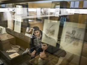 Ferdous Mominzda, left, a refugee from Afghanistan, views the exhibition at the Jewish barracks at the Sachsenhausen National Memorial in Oranienburg, Germany, Feb. 1, 2018.