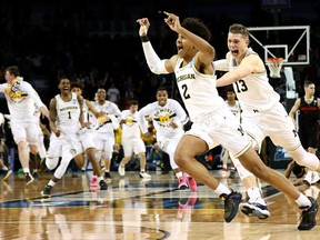 Michigan players celebrate Jordan Poole's three-point buzzer-beater against Houston in the second round of March Madness on March 17.