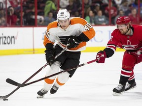 Philadelphia Flyers' Jordan Weal (40) handles the puck as Carolina Hurricanes' Joakim Nordstrom (42), of Sweden, reaches in with his stick during the first period of an NHL hockey game in Raleigh, N.C., Saturday, March 17, 2018.