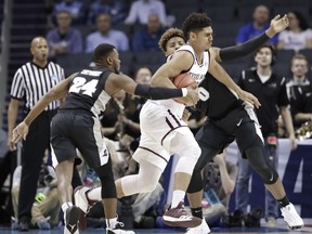 Texas A&M's Tyler Davis, center, drives between Providence's Kyron Cartwright, left, and Nate Watson, during the first half of a first-round game in the NCAA men's college basketball tournament in Charlotte, N.C., Friday, March 16, 2018.