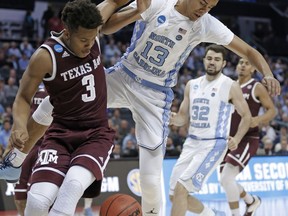 North Carolina's Cameron Johnson (13) and Texas A&M's Admon Gilder (3) battle for the ball during the first half of a second-round game in the NCAA men's college basketball tournament in Charlotte, N.C., Sunday, March 18, 2018.
