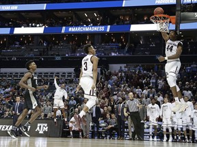 Texas A&M's Robert Williams (44) dunks against Providence as teammate Admon Gilder (3) celebrates during the second half of a first-round game in the NCAA men's college basketball tournament in Charlotte, N.C., Friday, March 16, 2018.