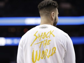 A UMBC player wears a T-shirt with "Shock The World" on it as the team warms up before their second-round game against Kansas State in the NCAA men's college basketball tournament in Charlotte, N.C., Sunday, March 18, 2018.
