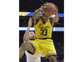 UMBC's Arkel Lamar (33) grabs a rebound in front of Virginia's Ty Jerome during the first half of a first-round game in the NCAA men's college basketball tournament in Charlotte, N.C., Friday, March 16, 2018.
