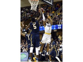 UNC-Greensboro forward Marvin Smith (1) shoots over East Tennessee State center Peter Jurkin (5) in the first half of an NCAA college basketball game for the Southern Conference tournament championship on Monday, March 5, 2018, in Asheville, N.C.