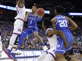 Duke's Trevon Duval (1) shoots as teammate Marques Bolden (20) watches and Kansas' Udoka Azubuike, left, and Marcus Garrett defend during the first half of a regional final game in the NCAA men's college basketball tournament Sunday, March 25, 2018, in Omaha, Neb.