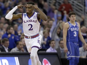 Kansas' Lagerald Vick, left, celebrates after making a 3-point basket as Duke's Grayson Allen is seen in the background during the second half of a regional final game against Duke in the NCAA men's college basketball tournament Sunday, March 25, 2018, in Omaha, Neb.