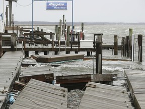 FILE - In this March 2, 2018 file photo, high winds and rough surf toss about the boat docks at Smuggler's Cove  in Stone Harbor, N.J.  Residents along the Northeast coast braced for more flooding during high tides Saturday even as the powerful storm that inundated roads, snapped trees and knocked out power to more than 2 million homes and businesses moved hundreds of miles out to sea.