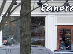 A hole is seen on a glass panel as a man leaves a Panera Bread restaurant in Princeton, N.J., where an armed man was holed up across the street from Princeton University's campus, Tuesday, March 20, 2018. Police say there are no known hostages in the Panera Bread, but it's not clear what sparked the standoff that began around 10 a.m. Tuesday. Authorities had shut down Princeton's downtown area, and two campus buildings were evacuated as a precaution. It wasn't immediately known if the gunman had any connection to the university. Classes are not in session at Princeton, which is on spring break.